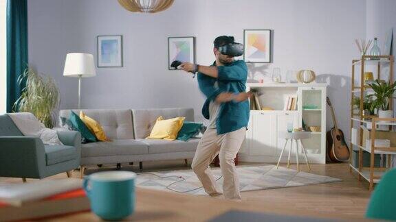 精力充沛的年轻人戴着虚拟现实耳机手持控制器在家玩视频游戏在客厅中玩VR射击游戏的人