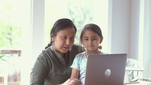 妈妈和女儿在用笔记本电脑