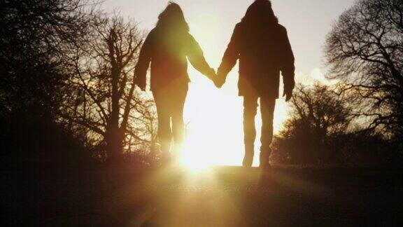 日落时分牵手散步的情侣