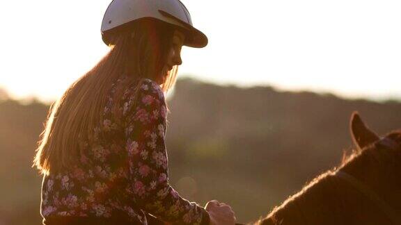 日落时分骑马的年轻女子
