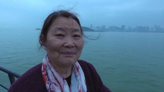 老妇人在游船上欣赏城市风景