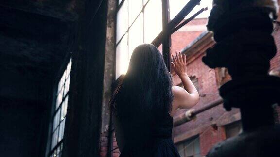 一个女人在废墟中望着窗外