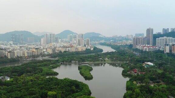 日落时分海南岛三亚市城市景观公园湖空中全景4k中国