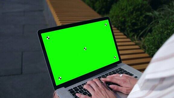 色度键绿色屏幕桌子上有绿色屏幕的女人在用电脑