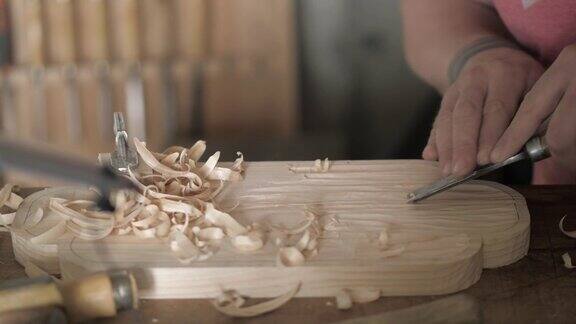 木雕师用凿子加工松木板