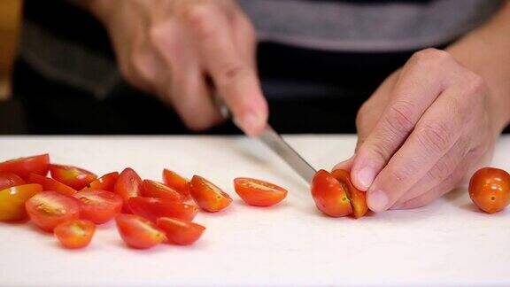 慢镜头拉近手用刀在厨房砧板上切番茄