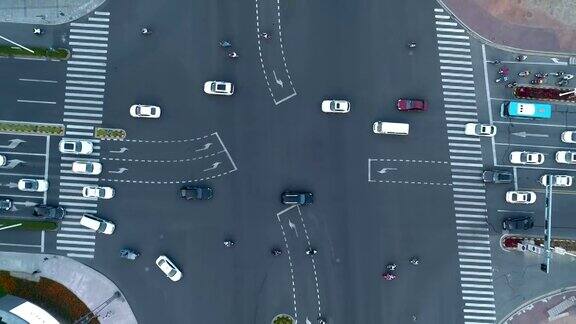 加速无人机拍摄的城市十字路口汽车和公交车行驶在大道上在日落时