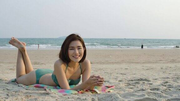 女孩穿着比基尼躺在沙滩上