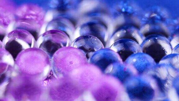 在蓝色和紫色表面旋转的水凝胶球关闭宏