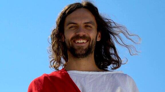非常快乐的耶稣看着镜头在天空的背景下拯救灵魂