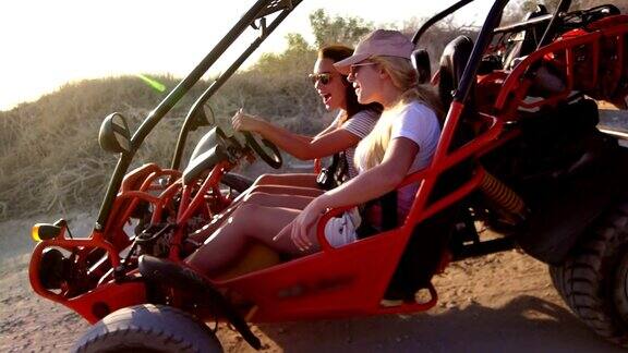 年轻的女孩们开着沙丘车在土路上享受极端的休息极端的旅行