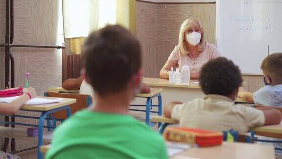 新冠肺炎疫情期间女教师和学生在教室佩戴防护口罩