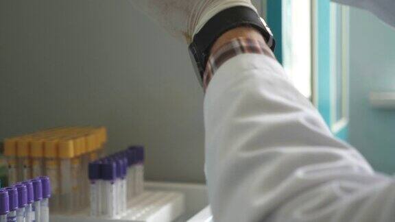 科学家或医生的手戴着医疗手套在实验室中操作试管医生检查COVID-19血液样本医疗保健理念与冠状病毒疫情近距离