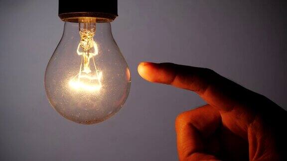 有创意的想法”观念观念与创新男人的手指触摸灯泡