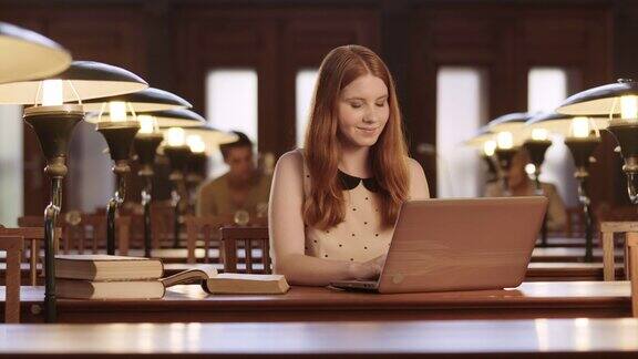一个年轻女子在图书馆里用笔记本电脑工作