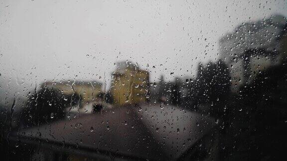 在恶劣的天气和下雨时你可以看到窗外的城市水滴从玻璃上滴下来