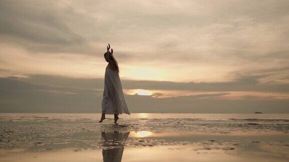 日落时分在海滩上跳舞的女人