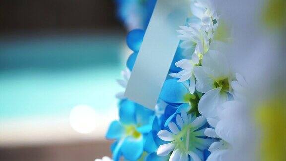 蓝色和白色的人造花阿罗哈挂在热带泳池旁