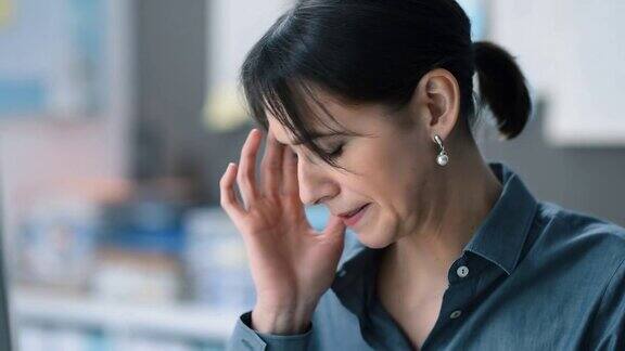 疲惫的商务女性在办公室工作有严重的头痛压力和疲劳