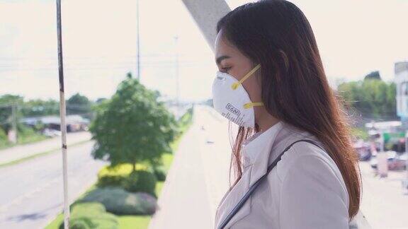 亚洲女性要去工作她戴着N95口罩防止PM2.5粉尘和雾霾