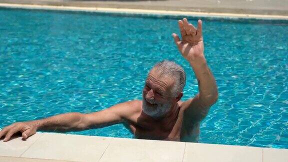老人在游泳池里游泳