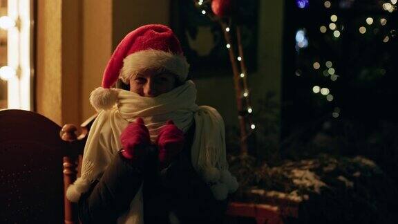 女人温暖的围巾红色的圣诞帽坐在长凳晚上圣诞装饰街道