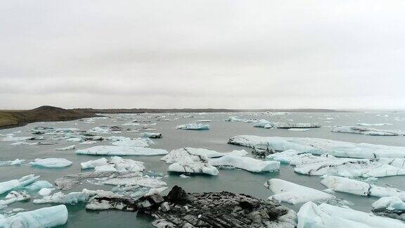 在冰岛南部海岸的Jokulsarlon泻湖上无人机在漂浮的冰山上空飞行