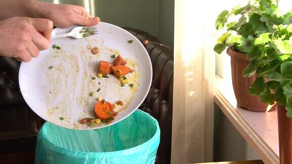 家庭主妇把烤好的蔬菜扔进垃圾桶