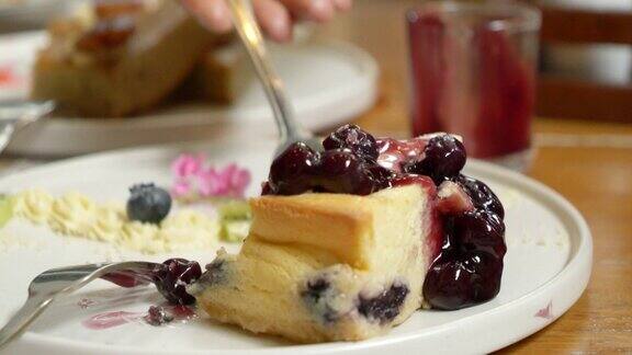 蓝莓蛋糕放在盘子里用叉子吃
