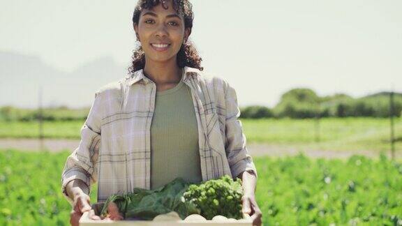 一个年轻女子在农场搬运一箱新鲜农产品的4k视频片段