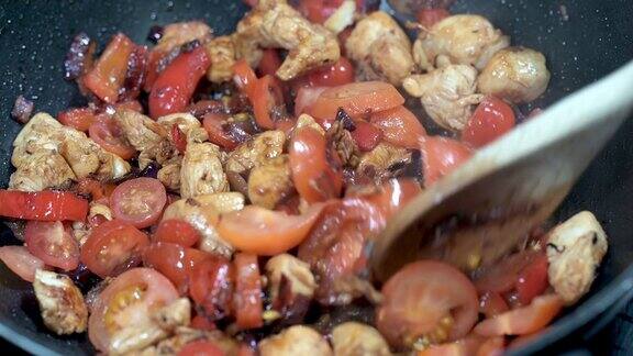 烹饪鸡肉西红柿辣椒和洋葱