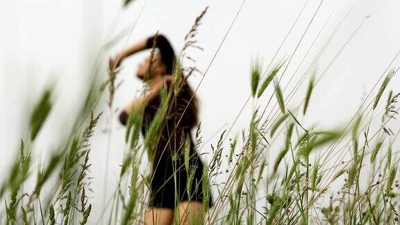 幸福的年轻女子独自在田野里跳舞