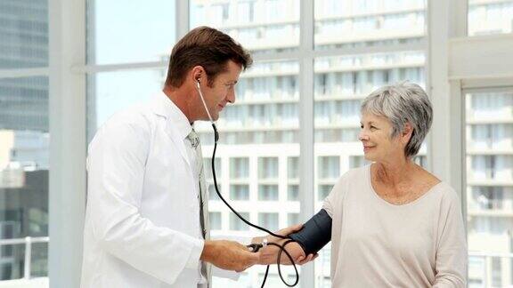 医生为一位老年妇女检查血压