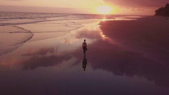 黄昏时走在海岸上的女孩