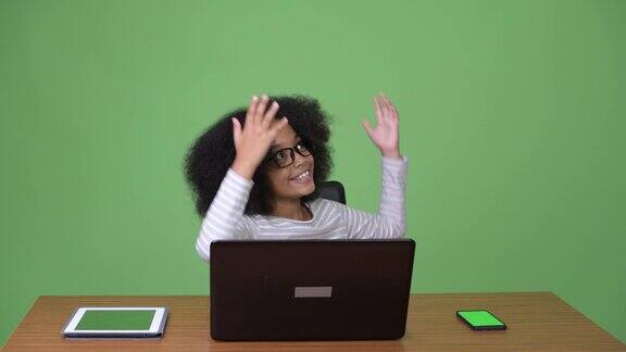年轻可爱的非洲女孩与非洲发型使用笔记本电脑
