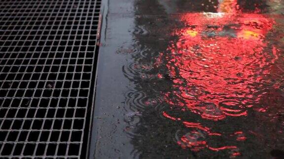 雨水洒在人行道上折射着霓虹灯