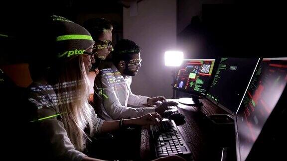 多民族IT专业人员的团队与计算机在黑暗中工作黑客计算机系统
