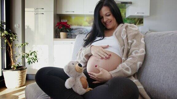 一名怀孕晚期的年轻女子抚摸着自己的肚子