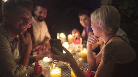 一个女人在吃饭的时候用手机在网上给她的朋友看有趣的事情