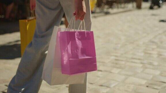 一个女孩在街上走着她提着购物袋人们在后面走着4k