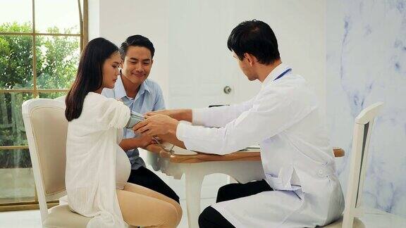 亚洲孕妇和她的丈夫会见产科医生在诊所
