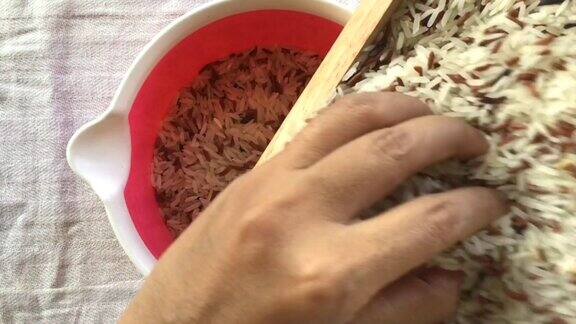 用手将糙米和白米倒入碗中