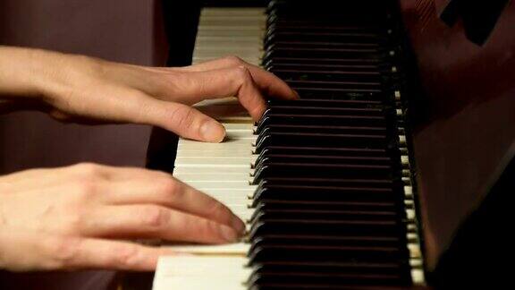 两只女人的手在一架漂亮的大钢琴上弹奏着一首温柔的古典音乐在弹钢琴的女人特写