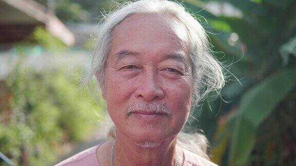 60年代男人的肖像微笑的亚洲老人老人看着相机