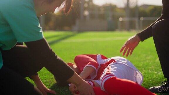 护士检查小学女生足球或足球运动员的伤势