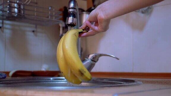 厨房里的水龙头里有自来水女人用自来水洗熟了的黄香蕉