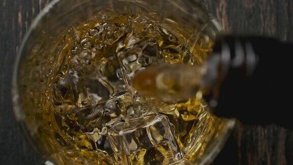 威士忌从棕色瓶子倒进玻璃杯前视图浇注波旁威士忌