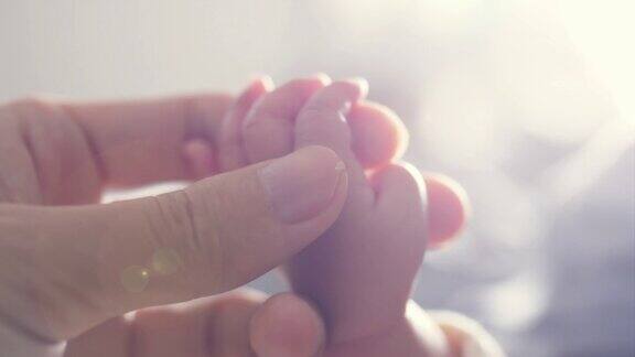 母亲抚摸新生婴儿的小手