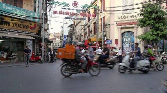 在越南河内繁忙的街道上摩托车和踏板车经过