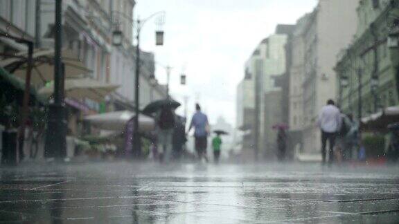 背景大雨天在城市街道真正的时间人们在雨中带着雨伞上下班模糊的散景自然背景